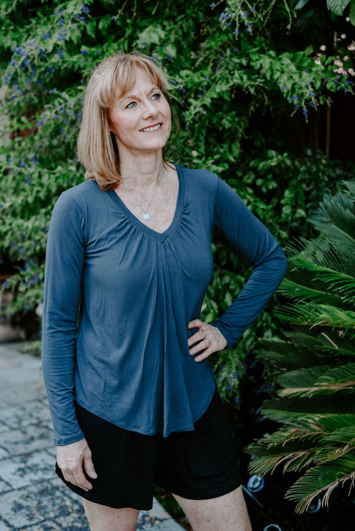 Model wearing Jia+Kate bamboo braless top in style Darci. Long sleeves in dusty navy color with center gathering at neckline